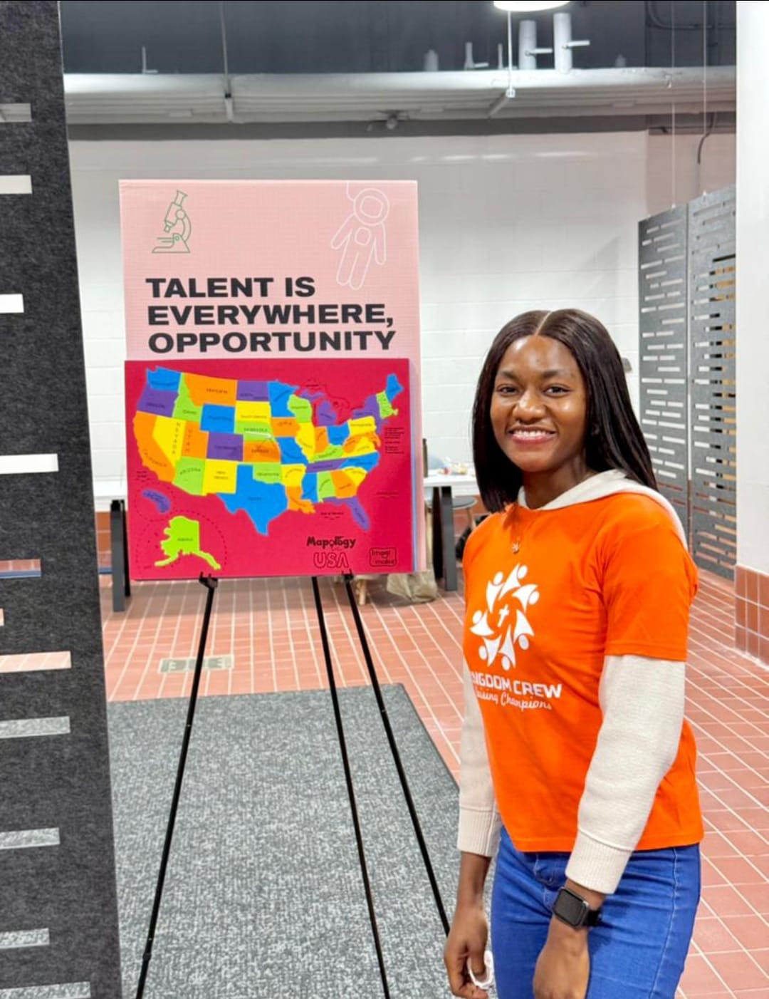 Kingdom Crew participant standing beside a talent and opportunity poster